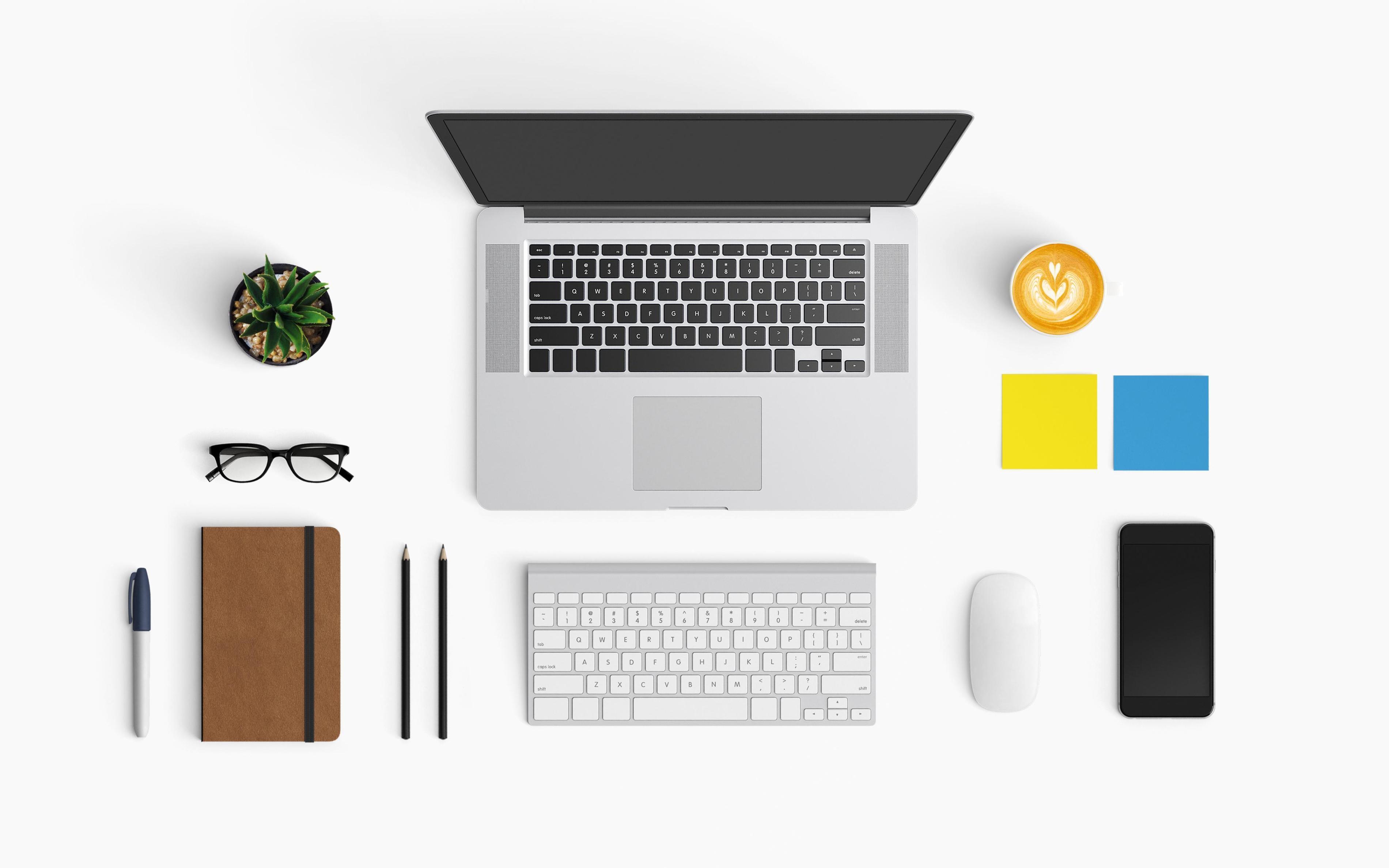 Een bureau met een laptop, schrijfgerief, koffie, post-its